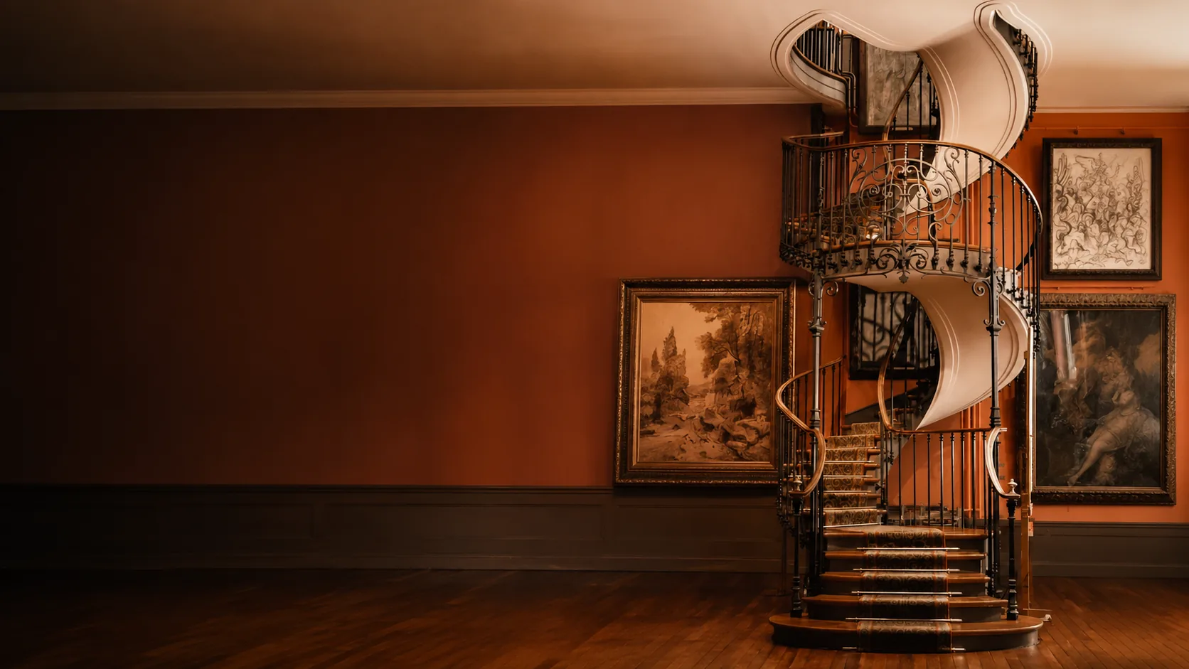 Escalier hélicoïdal en fer forgé à la rampe ornementée, dans un intérieur chaleureux aux tons terracotta