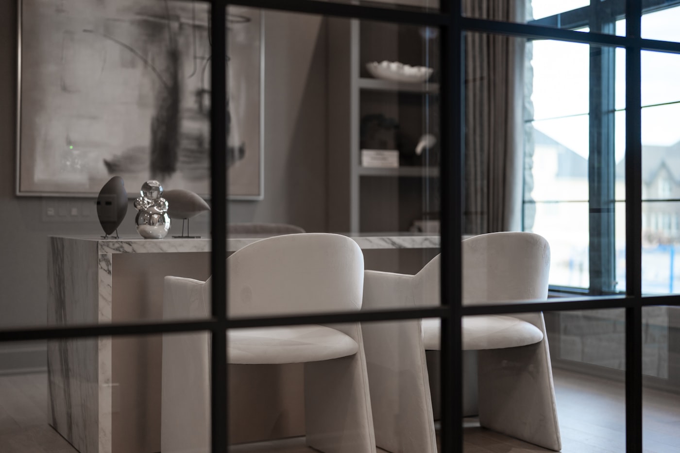 Verrière en acier à trame fine séparant un intérieur lumineux