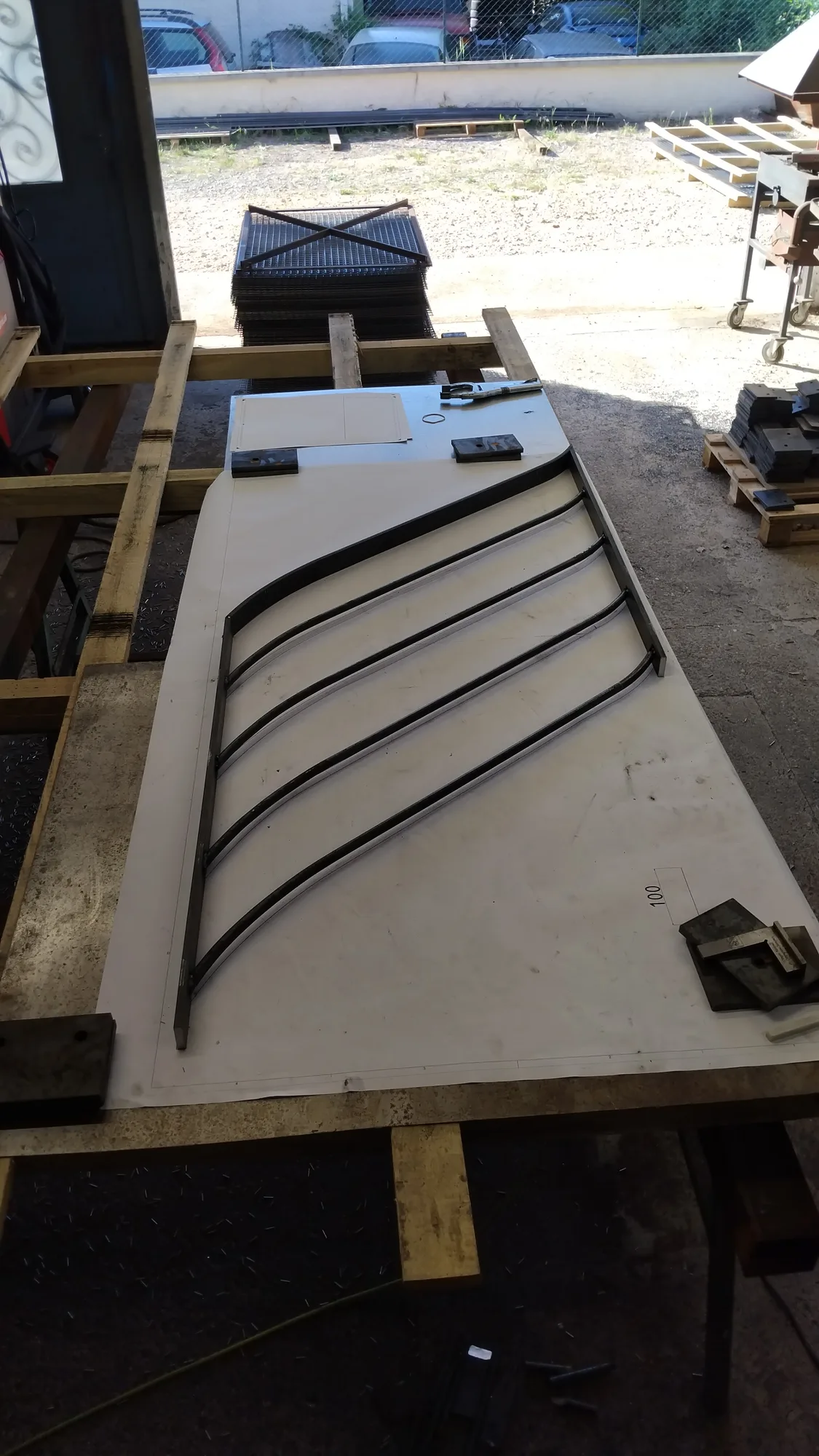 Vantail de portail sur mesure à barreaudage cintré, tracé sur épure à l’atelier